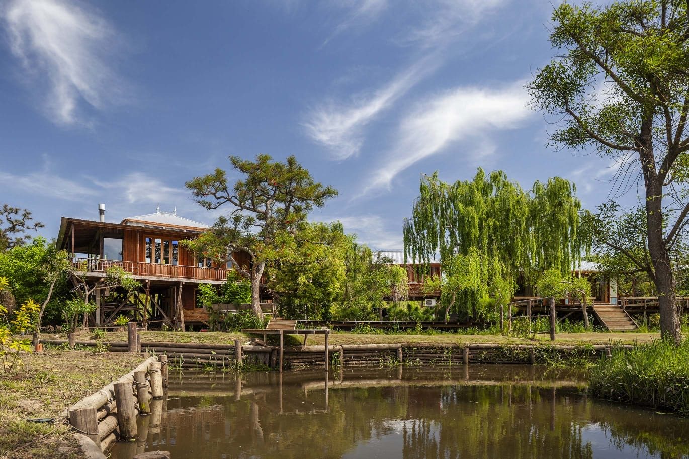Casas de madera del lugar frente a la laguna, rodeadas de árboles