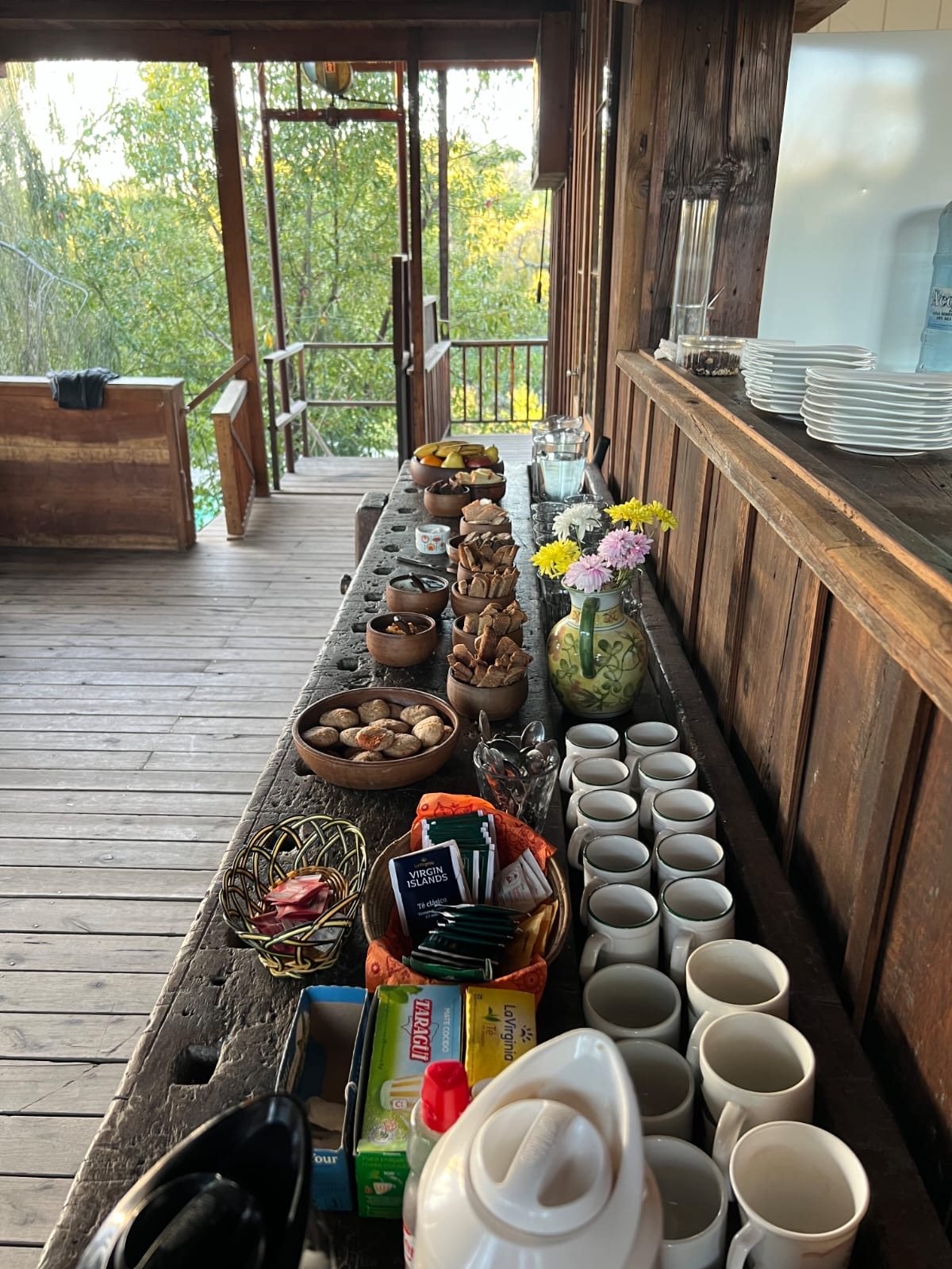 Merienda servida en la galería de madera con vista a los árboles
